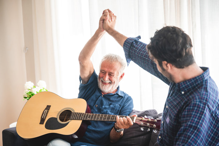 man playing guitar with instructor