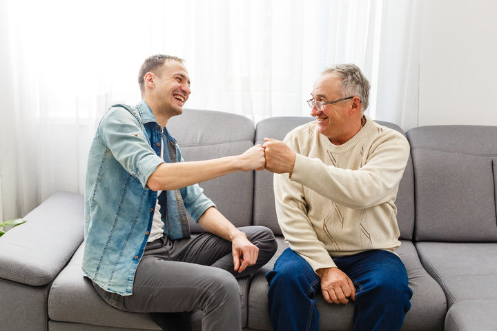 son and father bumping fists and smiling
