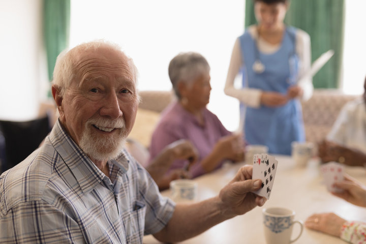 old people playing cards in care home
