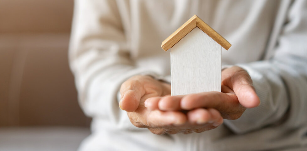 hands holding a wooden home decoration