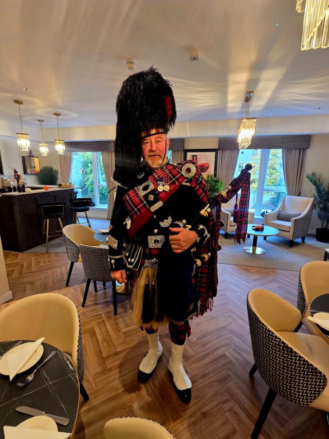 traditional scottish piper in the cafe of bower care home